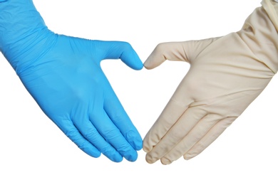 Doctor making heart shape with hands in different medical gloves on white background