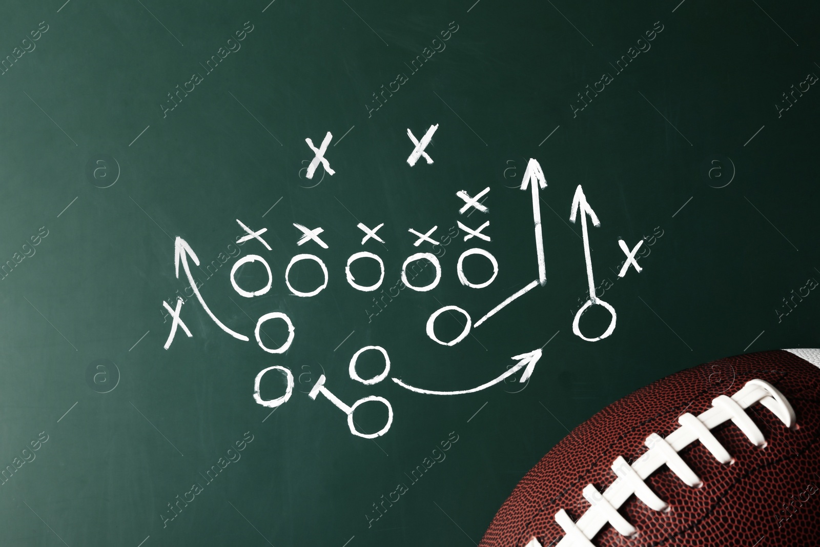 Photo of Chalkboard with football game scheme and rugby ball, top view