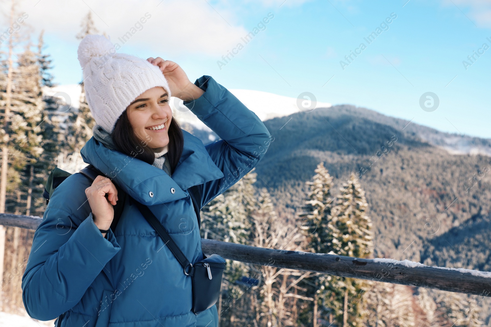 Photo of Happy young woman spending winter vacation in mountains. Space for text