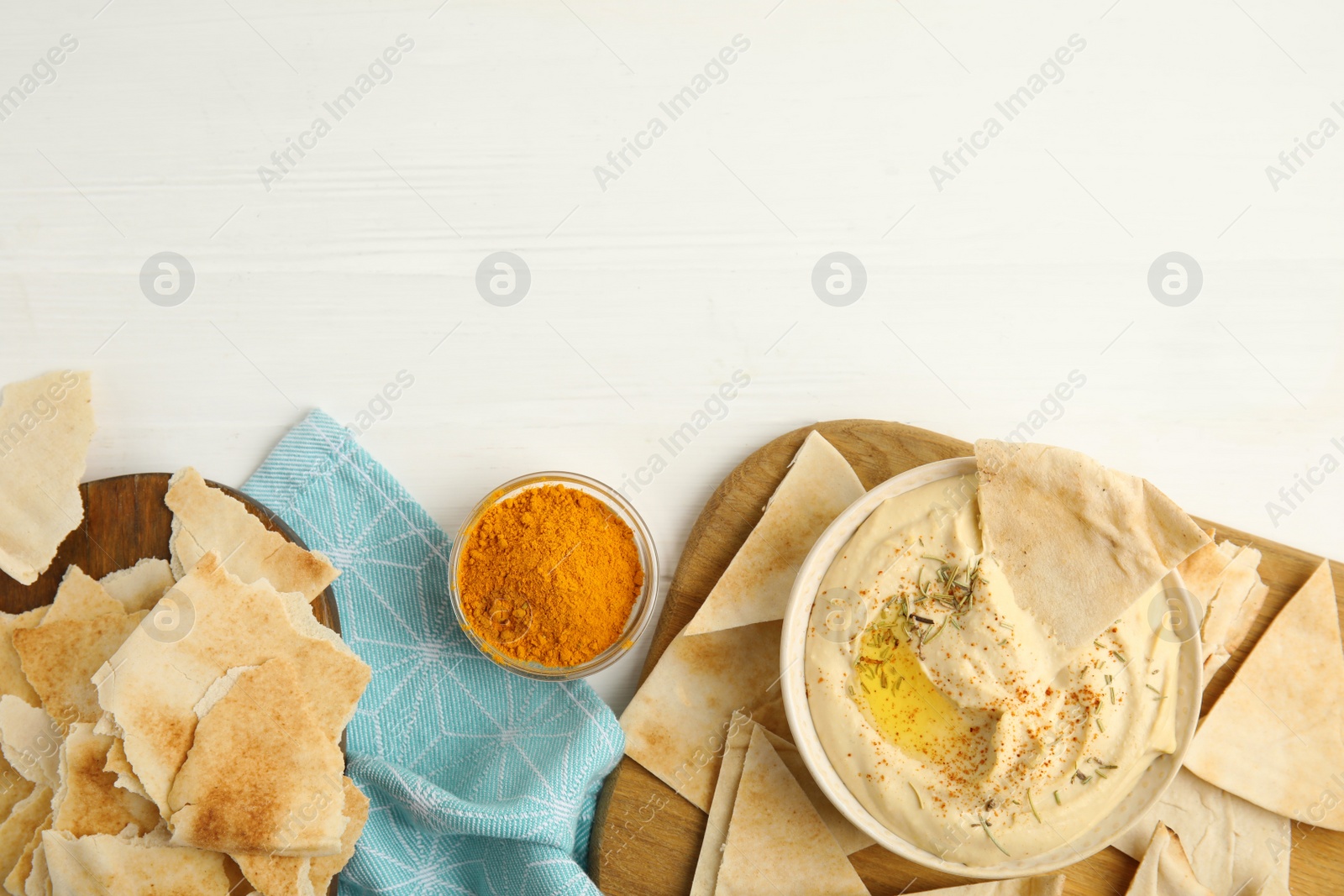 Photo of Delicious hummus with pita chips on white wooden table, flat lay. Space for text