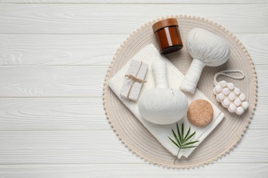 Composition of herbal bags and spa products on white wooden table, top view. Space for text