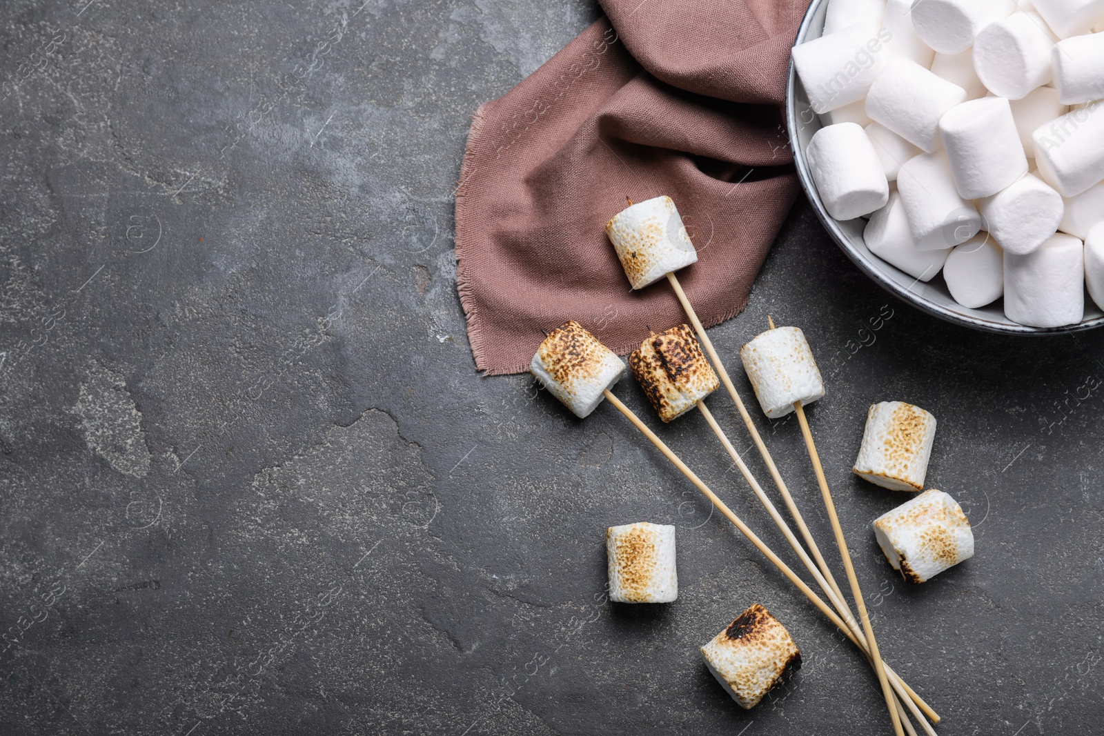 Photo of Fresh and roasted marshmallows on grey table, flat lay. Space for text