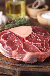 Photo of Piece of raw beef meat on wooden board, closeup