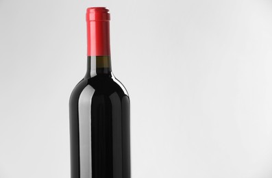 Photo of Bottle of expensive red wine on light background. Space for text