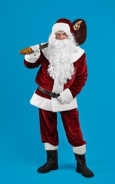 Santa Claus with electric guitar on blue background. Christmas music