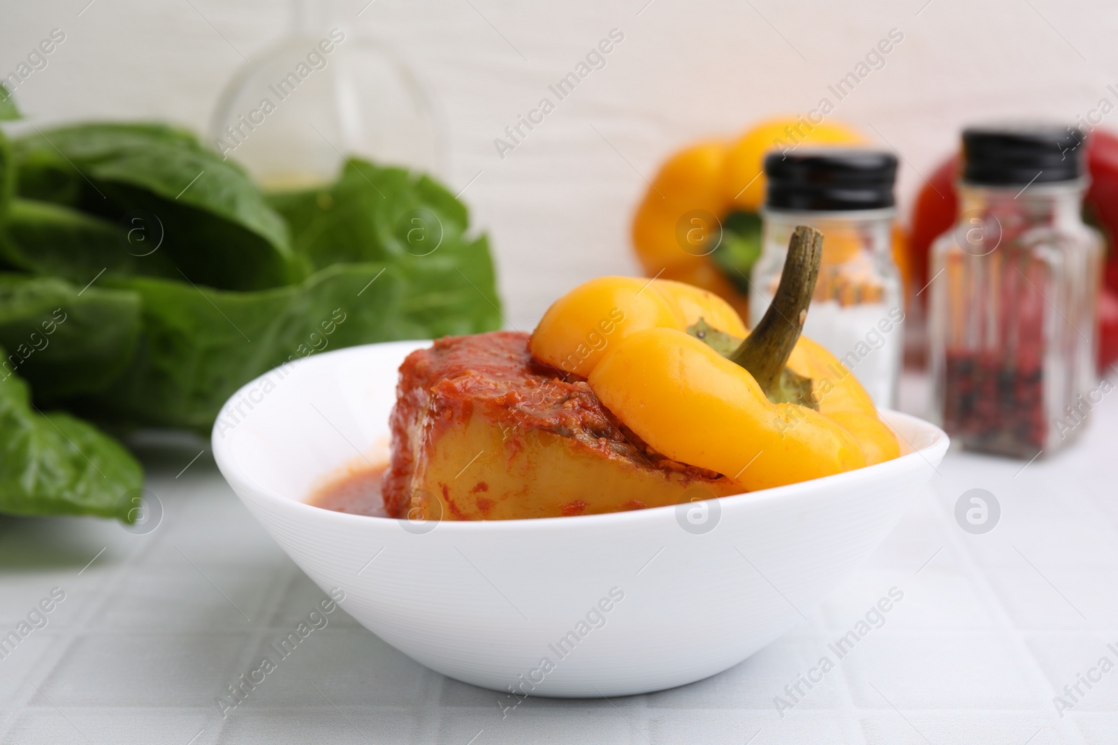 Photo of Delicious stuffed bell pepper on white tiled table