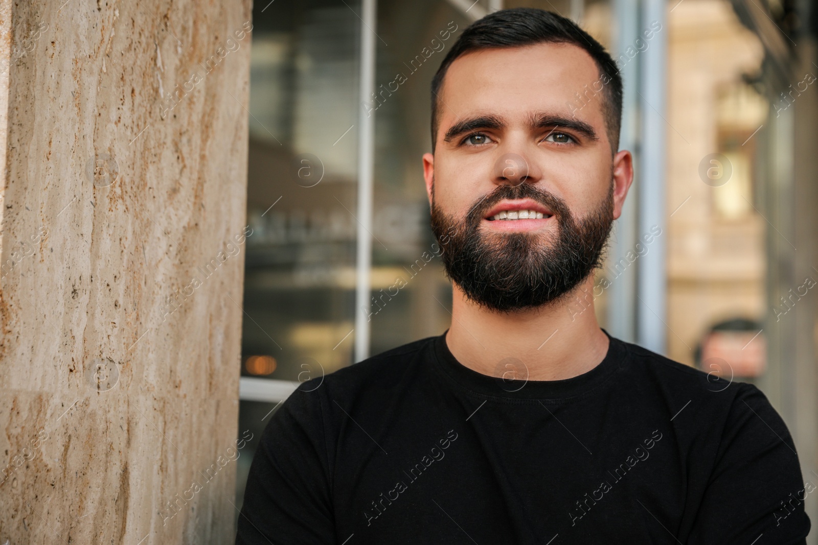 Photo of Portrait of happy handsome man near building outdoors. Space for text