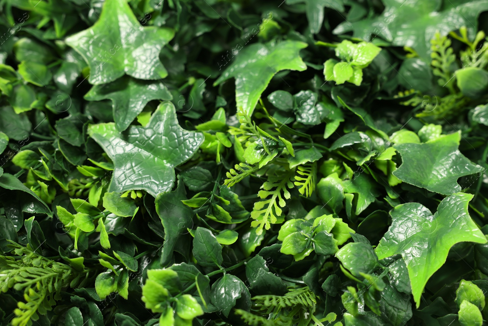 Photo of Green artificial plants as background, closeup view