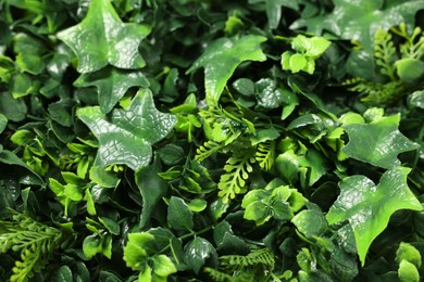 Green artificial plants as background, closeup view