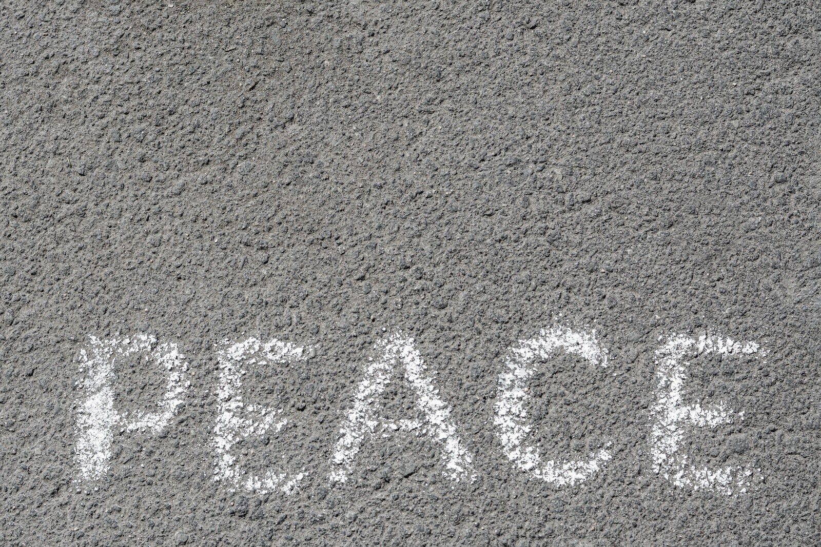 Photo of Word Peace written with white chalk on asphalt outdoors, top view. Space for text