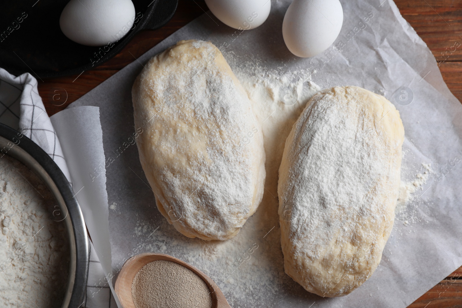 Photo of Raw dough, eggs and flour on wooden table, flat lay. Cooking ciabatta