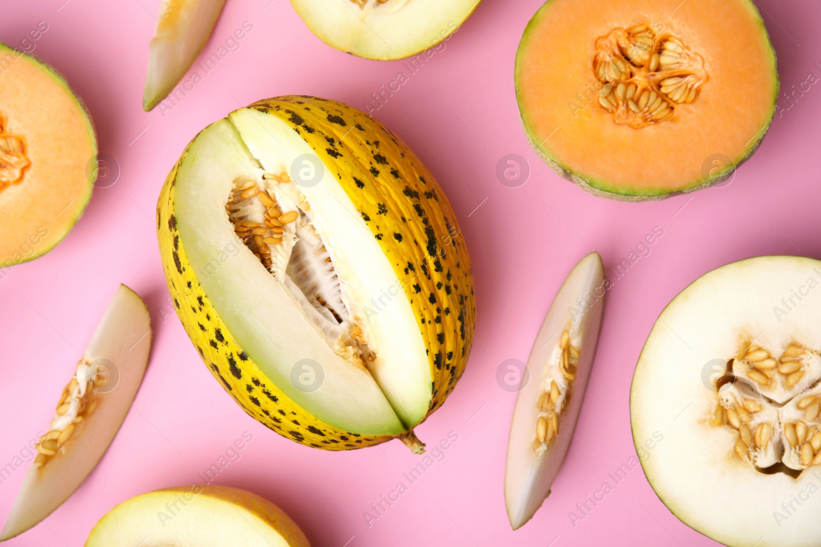 Photo of Tasty colorful ripe melons on pink background, flat lay