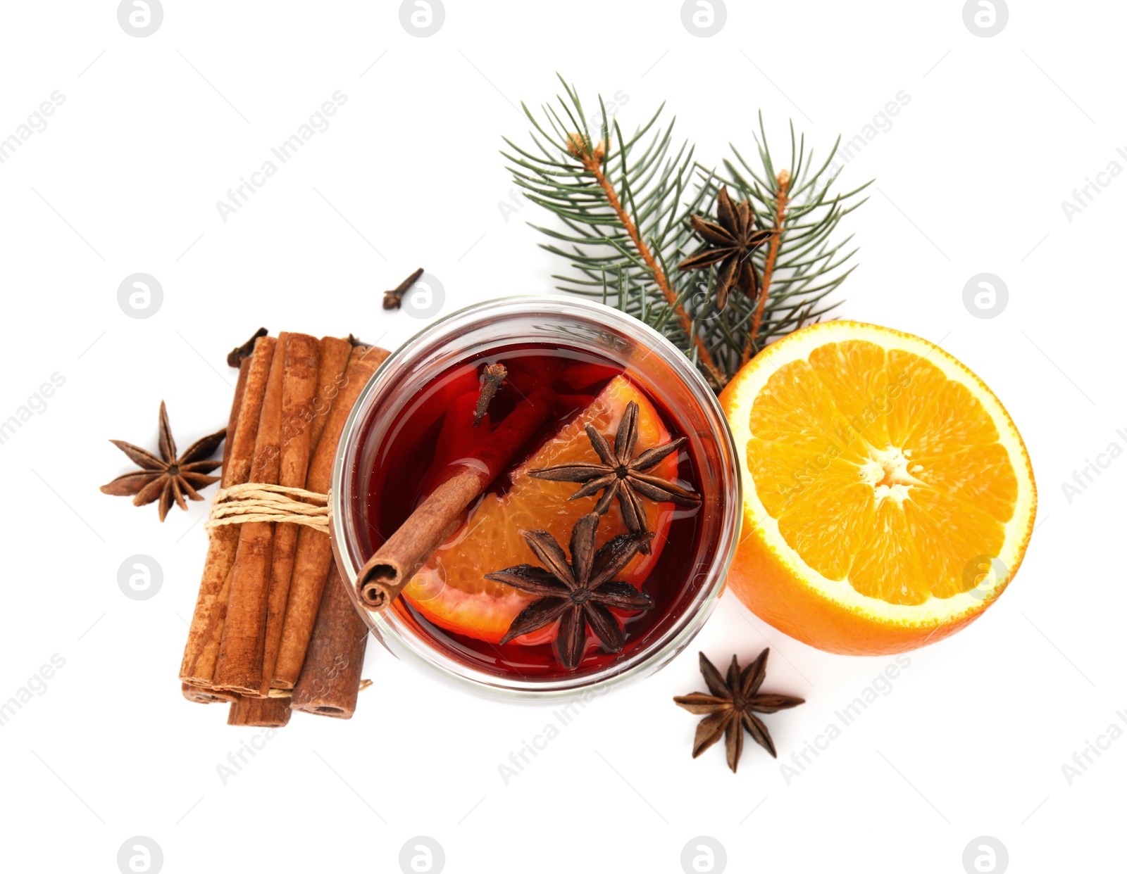 Photo of Glass of mulled wine with fir branch, cinnamon and orange isolated on white, top view