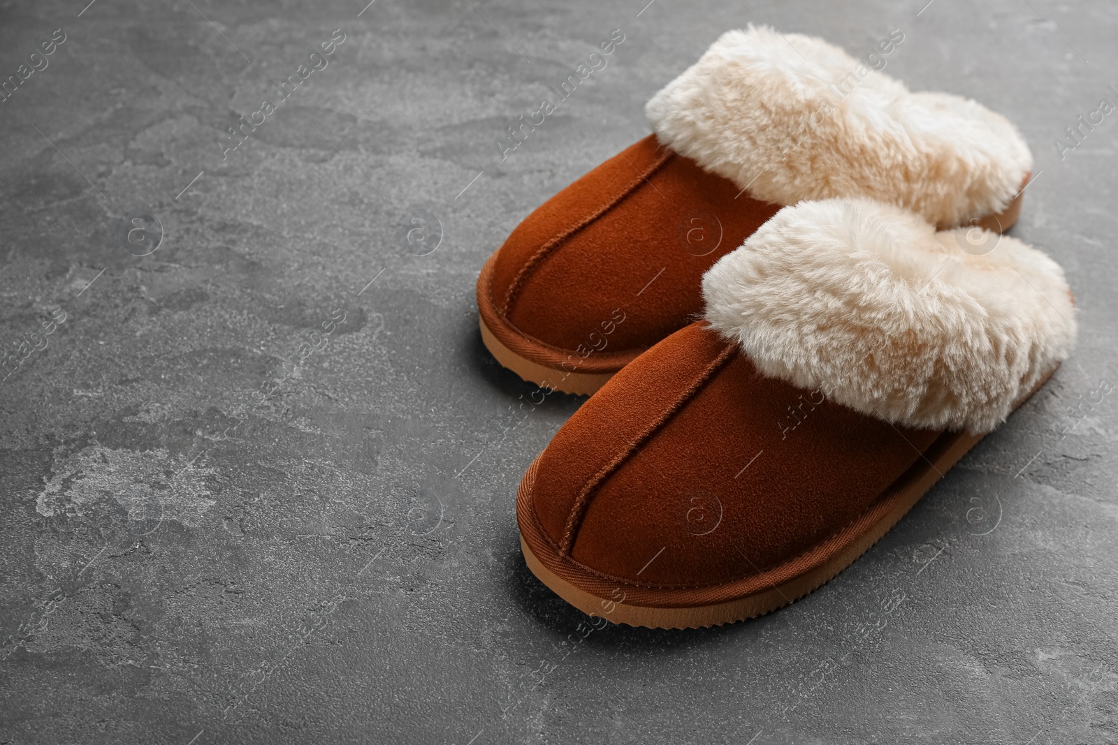 Photo of Pair of stylish soft slippers on grey background