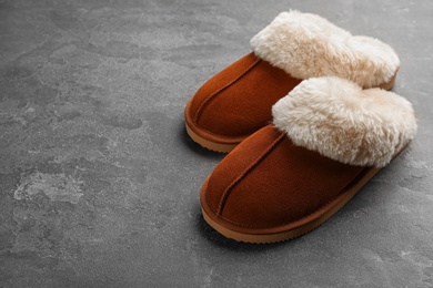 Pair of stylish soft slippers on grey background