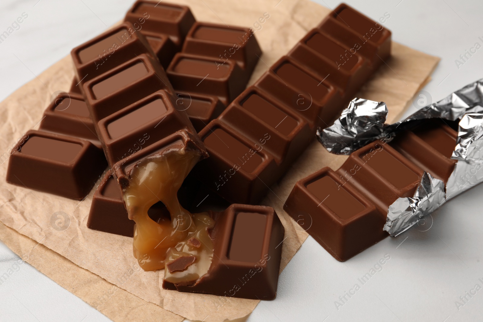 Photo of Tasty chocolate bars on white table, closeup