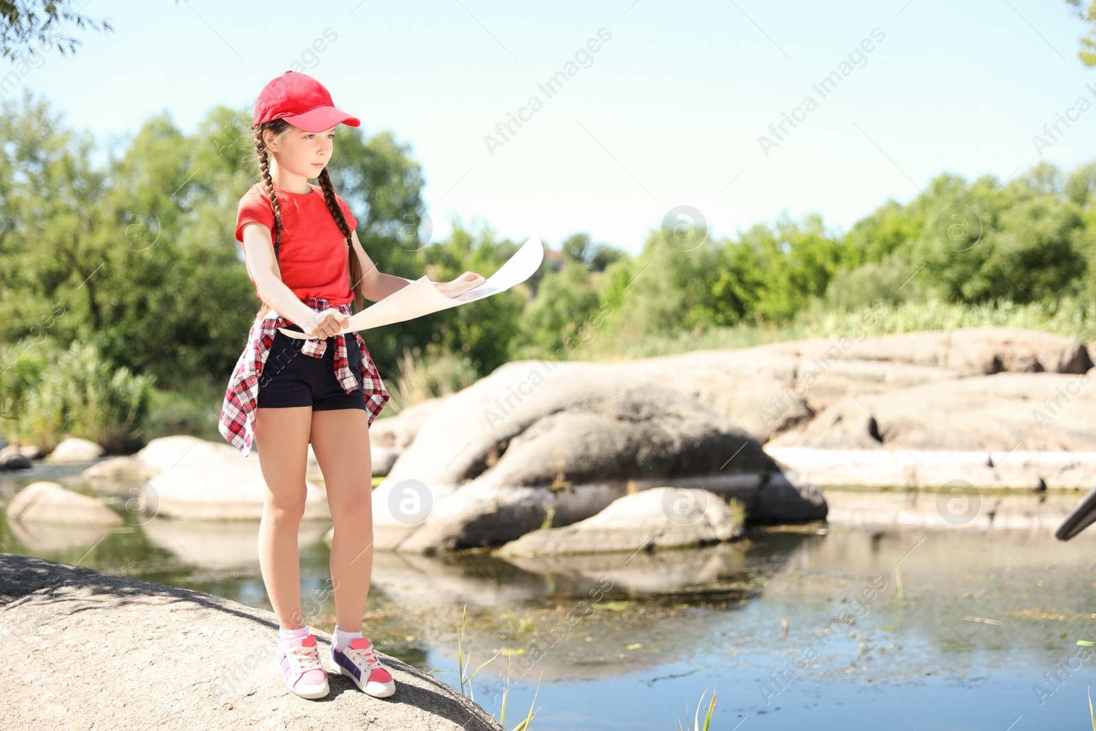 Photo of Little girl with map outdoors. Summer camp