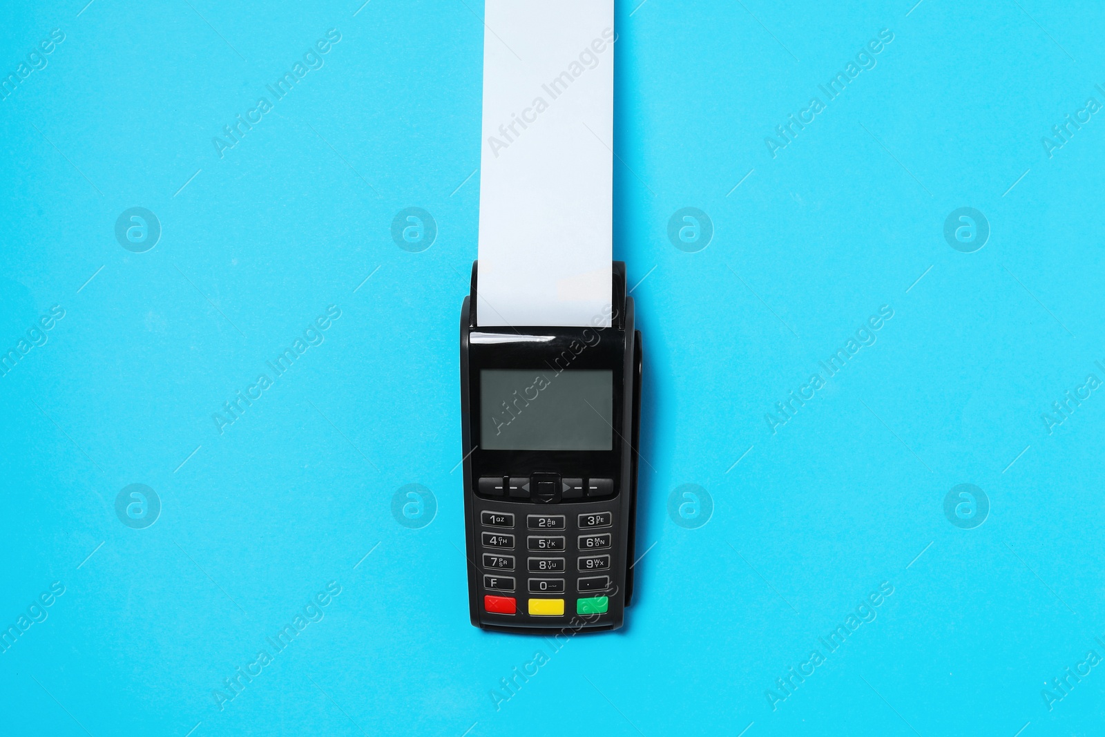 Photo of Payment terminal with thermal paper for receipt on light blue background, top view