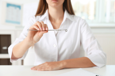 Photo of Speech therapist with logopedic probe in clinic, closeup