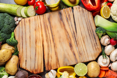 Fresh products and wooden board with space for text, flat lay. Healthy cooking