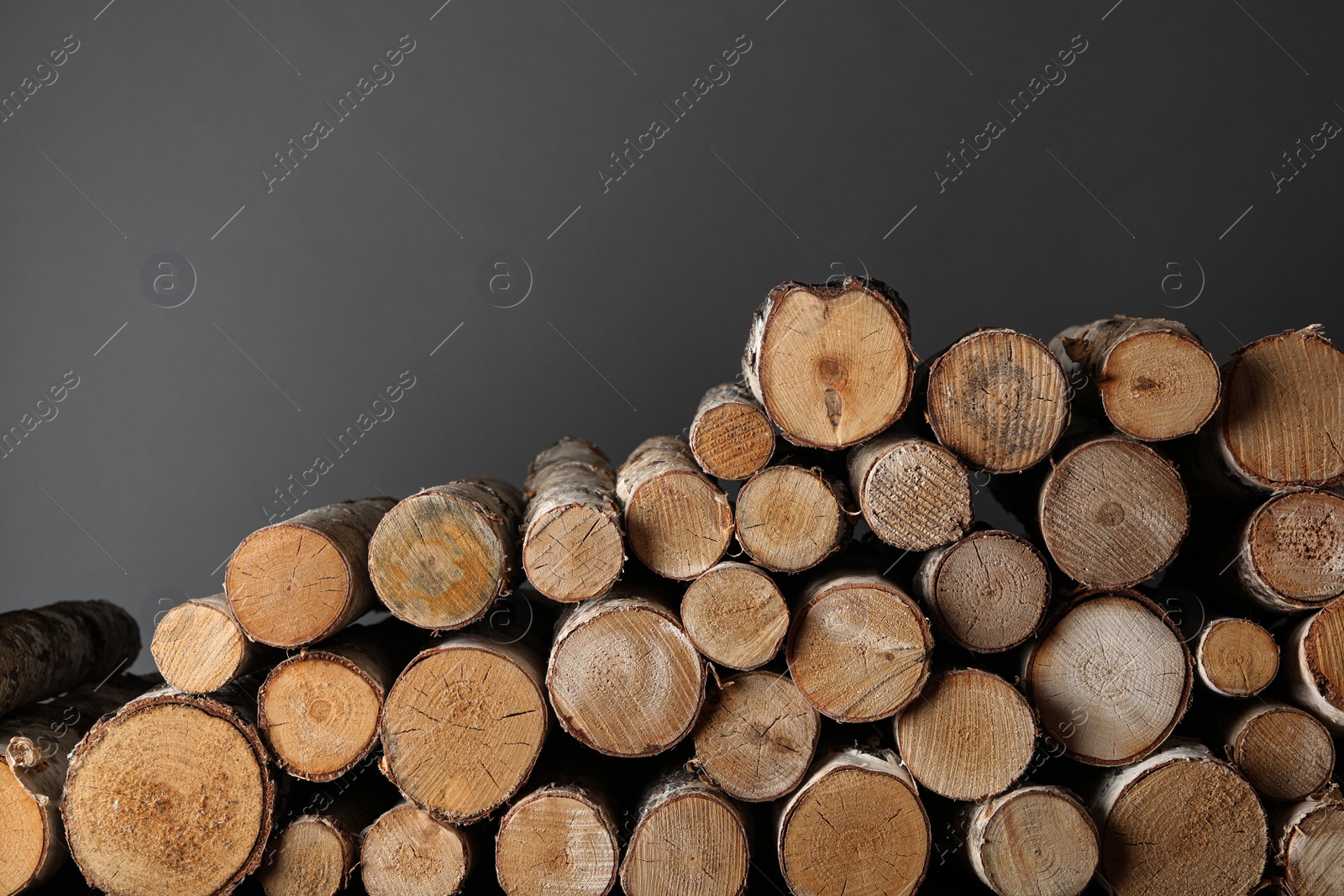 Photo of Cut firewood on grey background. Heating in winter