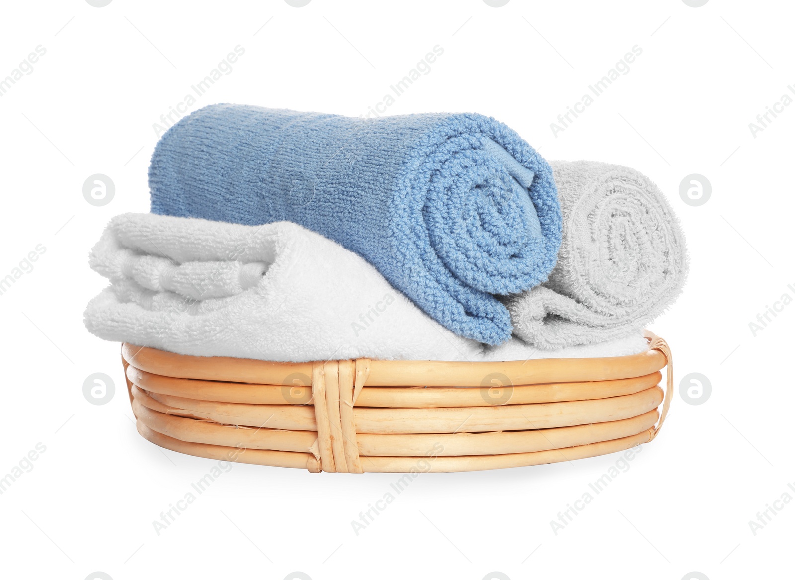 Photo of Wicker basket with rolled bath towels isolated on white