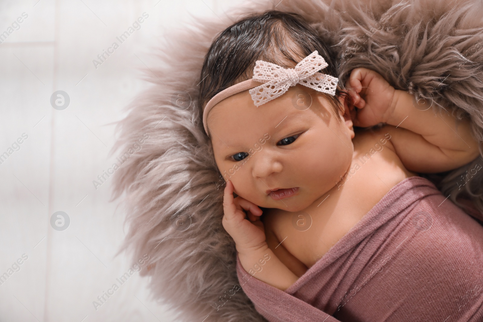 Photo of Cute newborn baby lying on fuzzy blanket, top view. Space for text