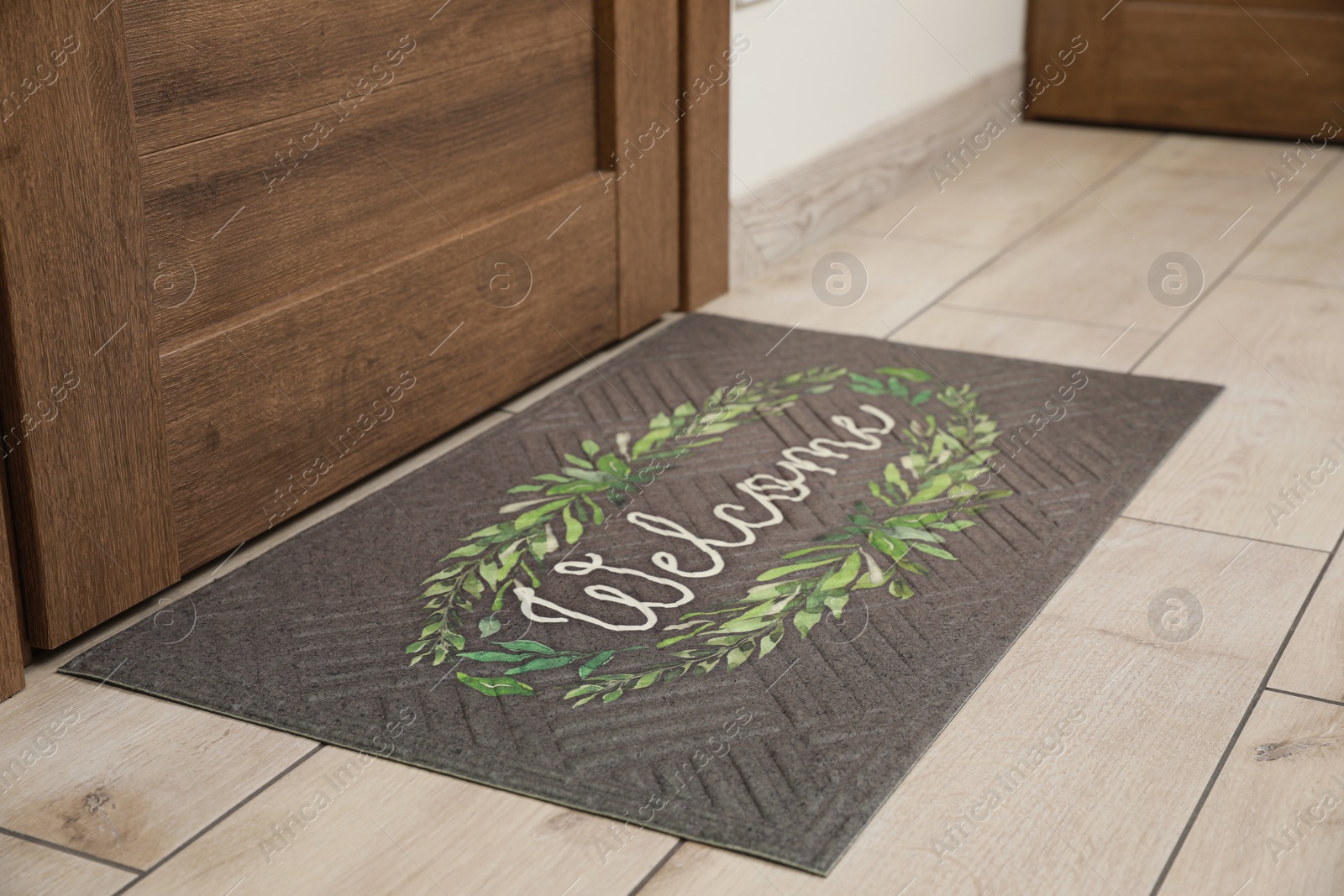 Photo of Beautiful doormat with word Welcome on floor near entrance