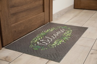 Photo of Beautiful doormat with word Welcome on floor near entrance