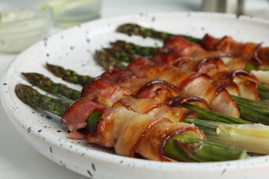 Photo of Oven baked asparagus wrapped with bacon on plate, closeup