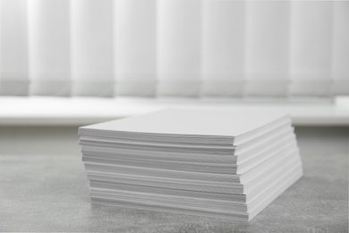 Photo of Stack of paper sheets on grey table