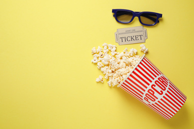 Photo of Flat lay composition with delicious popcorn on yellow background. Space for text