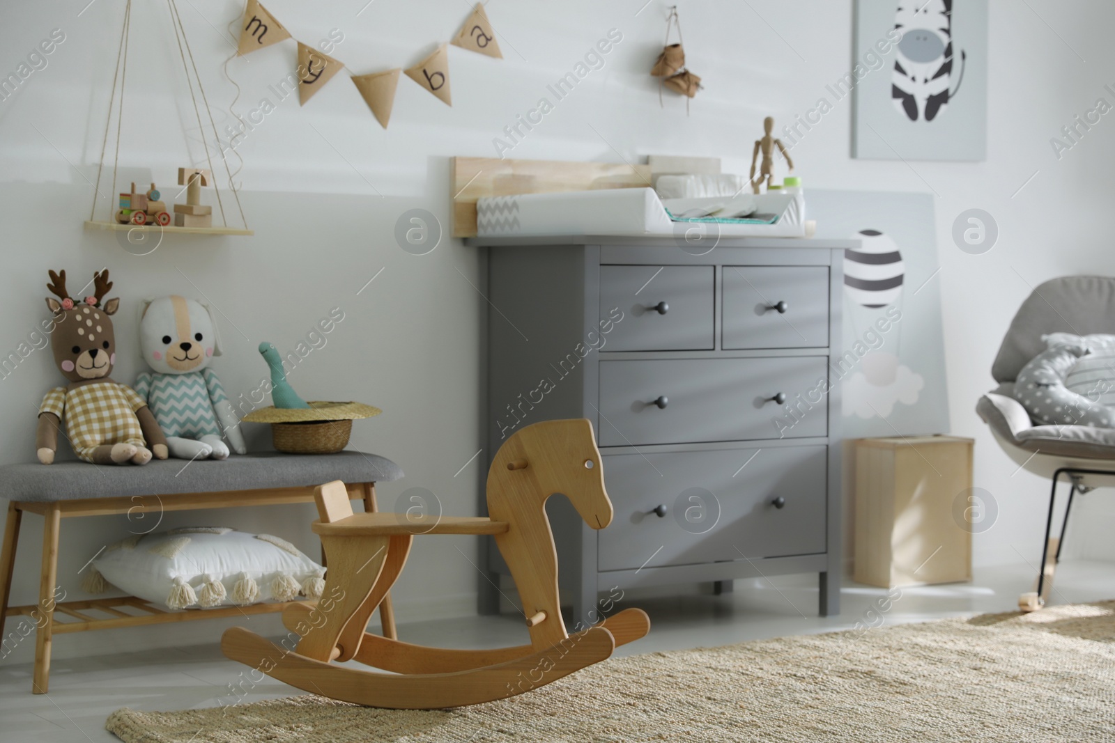 Photo of Beautiful baby room interior with toys and modern changing table