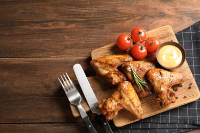 Photo of Flat lay composition with delicious barbecued chicken on wooden background. Space for text