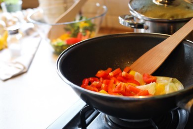 Photo of Cooking fresh vegetables in frying pan on stove, closeup. Space for text