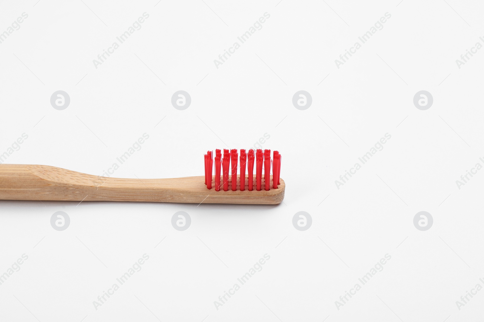 Photo of Bamboo toothbrush with red bristle isolated on white
