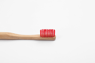 Bamboo toothbrush with red bristle isolated on white