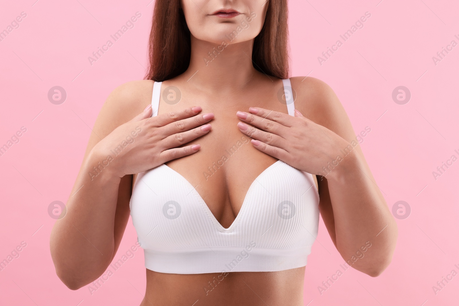 Photo of Woman with beautiful breast on pink background, closeup