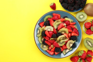Photo of Plate of yummy fruit salad and ingredients on yellow background, flat lay. Space for text