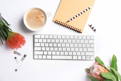 Photo of Creative flat lay composition with tropical flowers, stationery and computer keyboard on white background