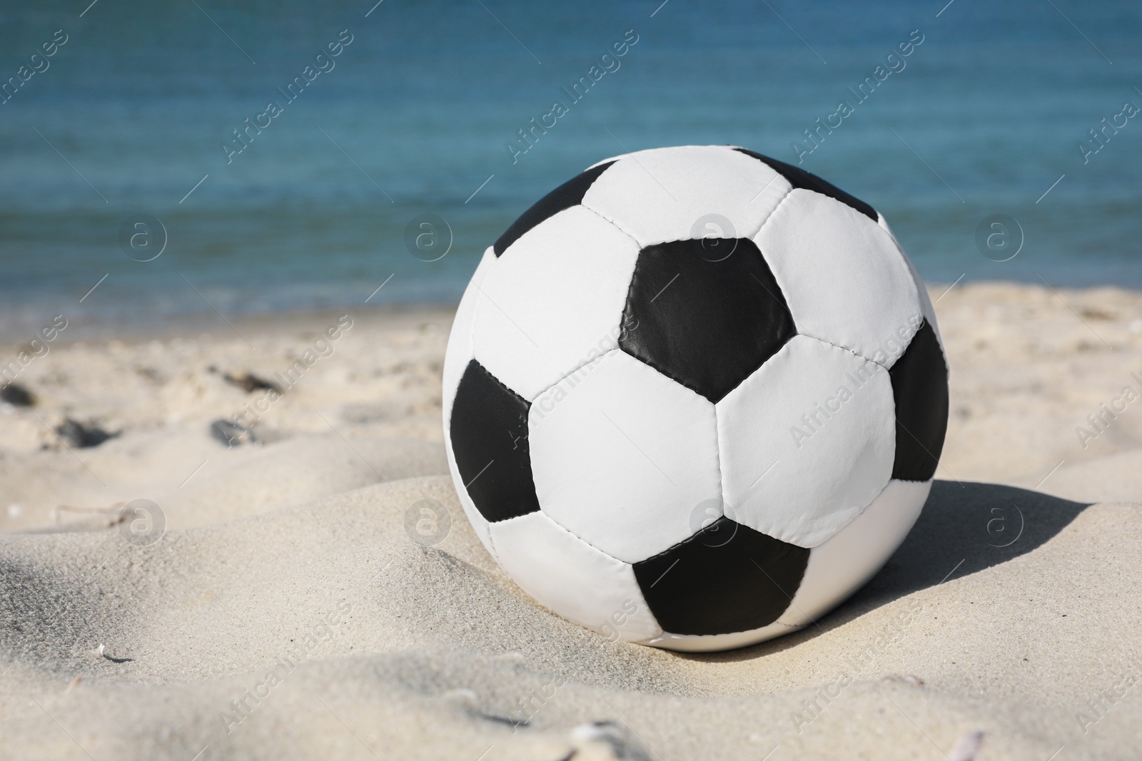 Photo of Soccer ball on beach near sea. Football equipment