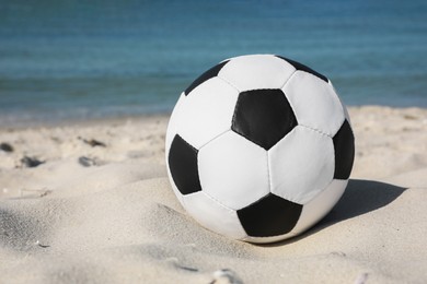 Soccer ball on beach near sea. Football equipment