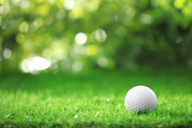 Photo of Golf ball on green grass against blurred background