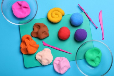 Photo of Flat lay composition with colorful plasticine on light blue background