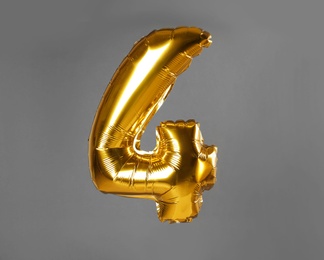 Photo of Golden number four balloon on grey background