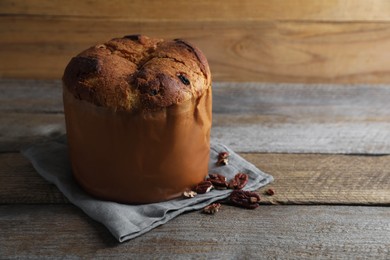 Photo of Delicious Panettone cake and raisins on wooden table, space for text. Traditional Italian pastry