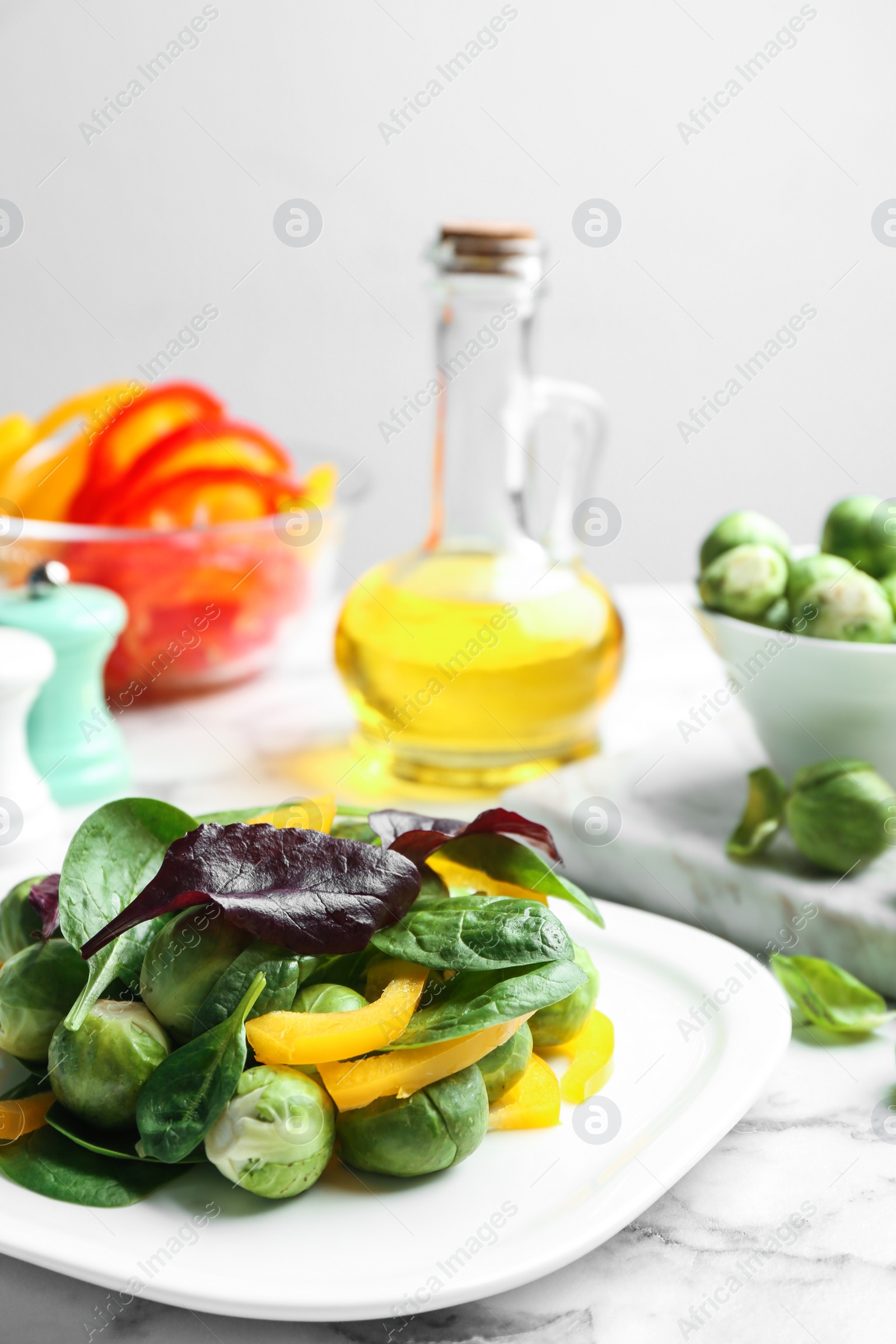 Photo of Tasty salad with Brussels sprouts on white marble table