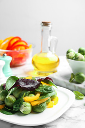 Photo of Tasty salad with Brussels sprouts on white marble table