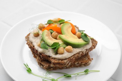 Photo of Tasty vegan sandwich with avocado, chickpeas and bell pepper on white table, closeup