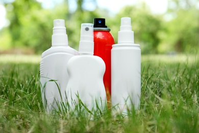 Bottles of insect repellent on green grass